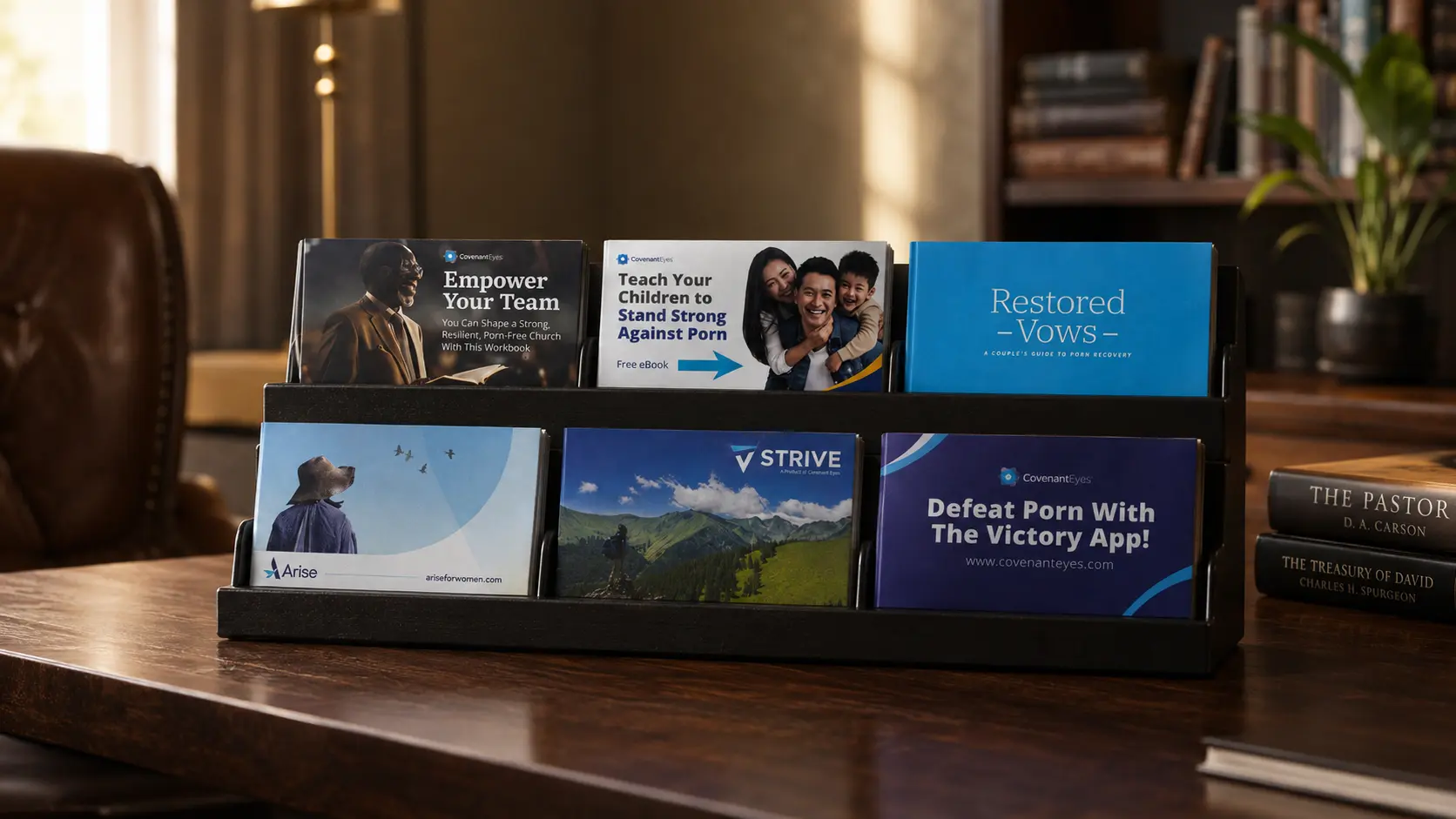 The six-card display on a desk in a pastor&rsquo;s office, books and a lamp behind it.