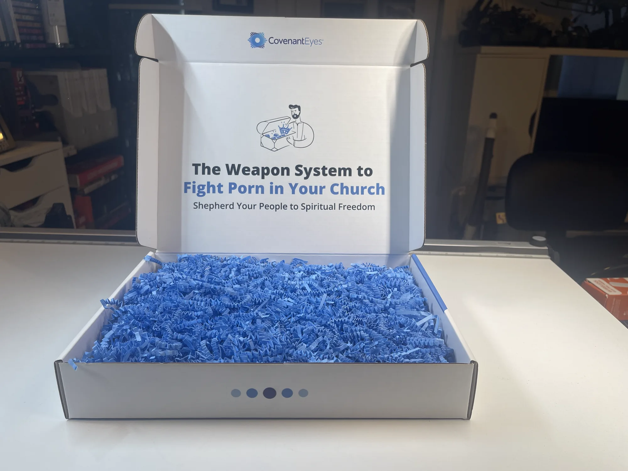 The shipped kit open and empty, blue crinkle filler in the tray and the interior lid message visible.